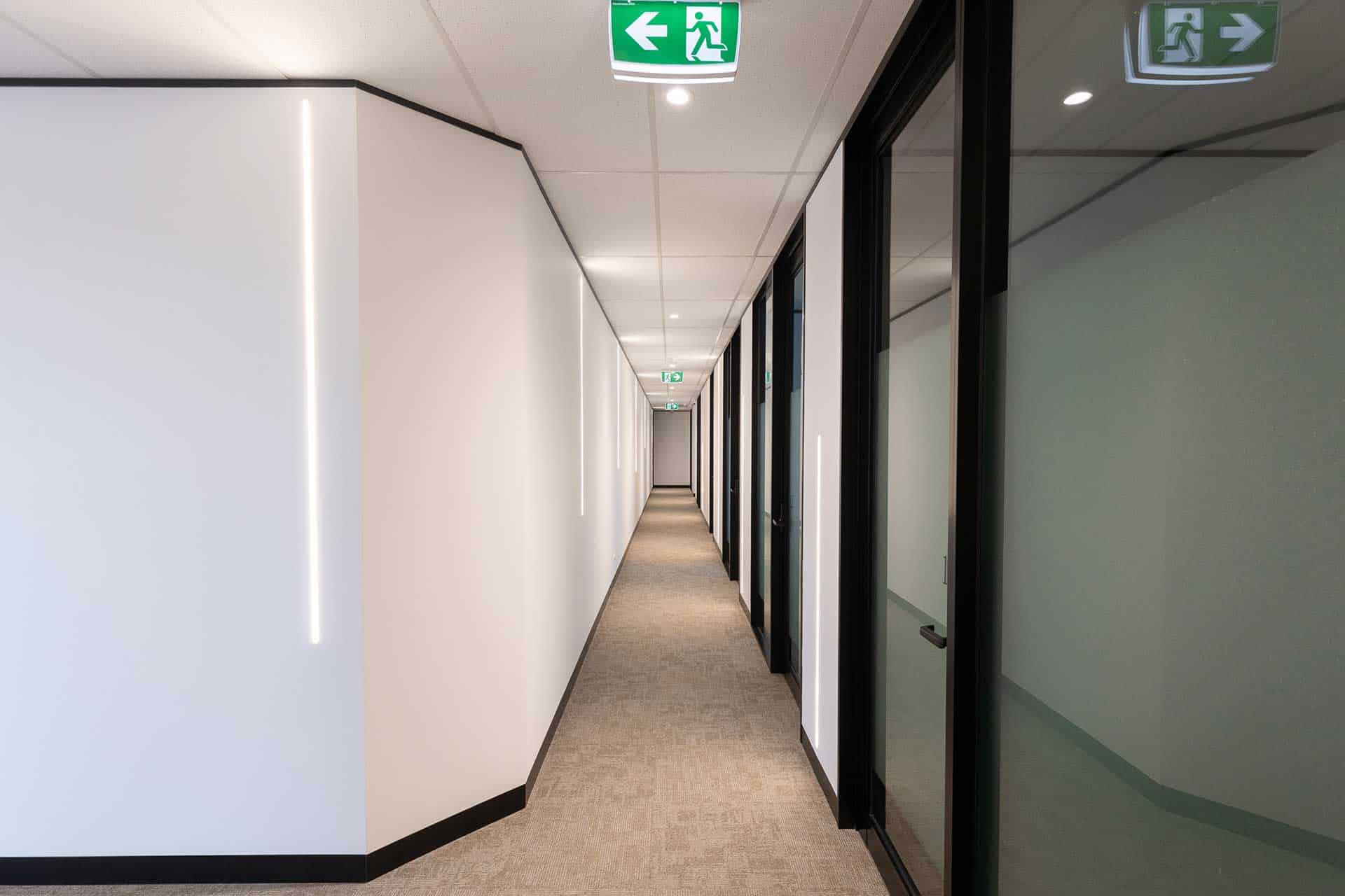 Gold Coast office fitout hallway with modern lighting by Airey Building Group.