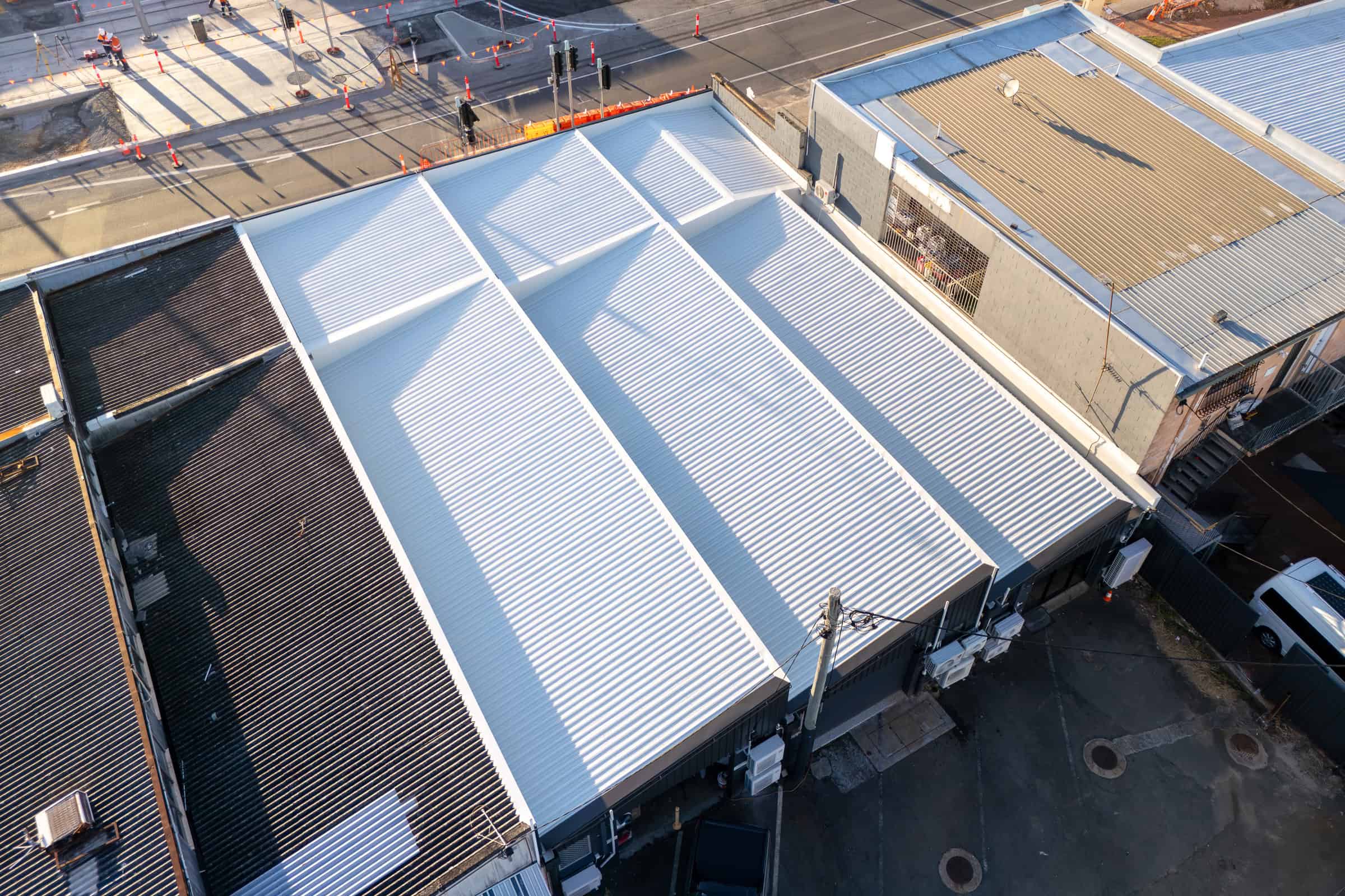 Aerial view of a commercial roof replacement completed by Airey Building Group at 2544 Gold Coast Highway, Mermaid Beach, featuring new Colorbond® roof sheeting installed as part of a major commercial building refurbishment. Commercial roof replacement Gold Coast Commercial roofing contractor Gold Coast Colorbond commercial roofing Industrial roof replacement Commercial reroof Mermaid Beach Building refurbishment Gold Coast Commercial building maintenance Warehouse roof replacement Commercial construction Gold Coast Airey Building Group